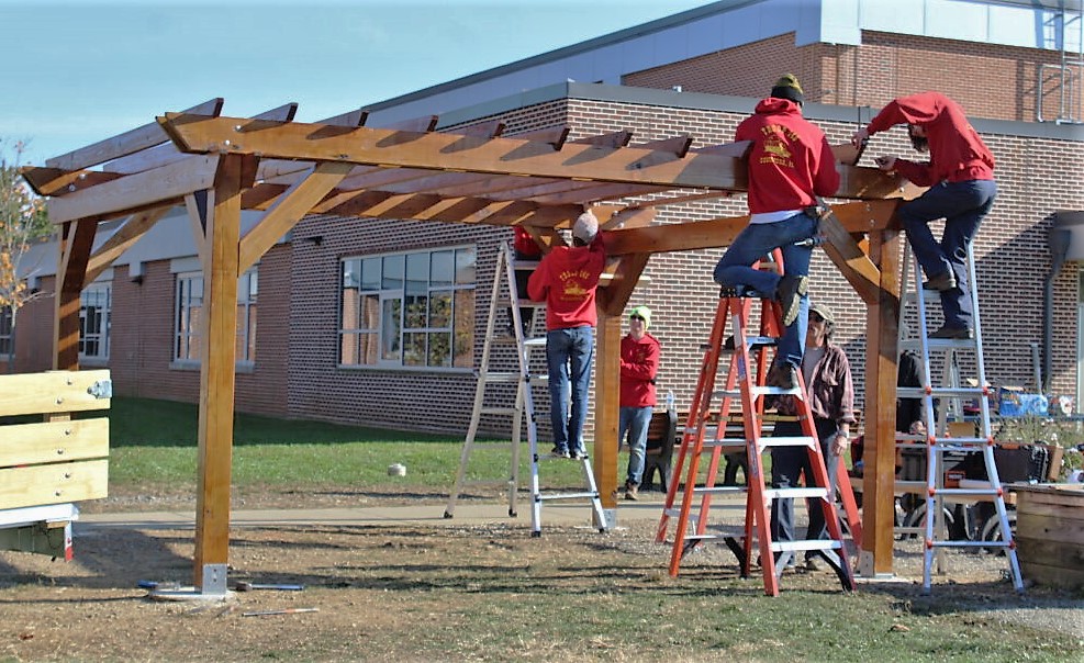 Workers complete the top portions of the pergola