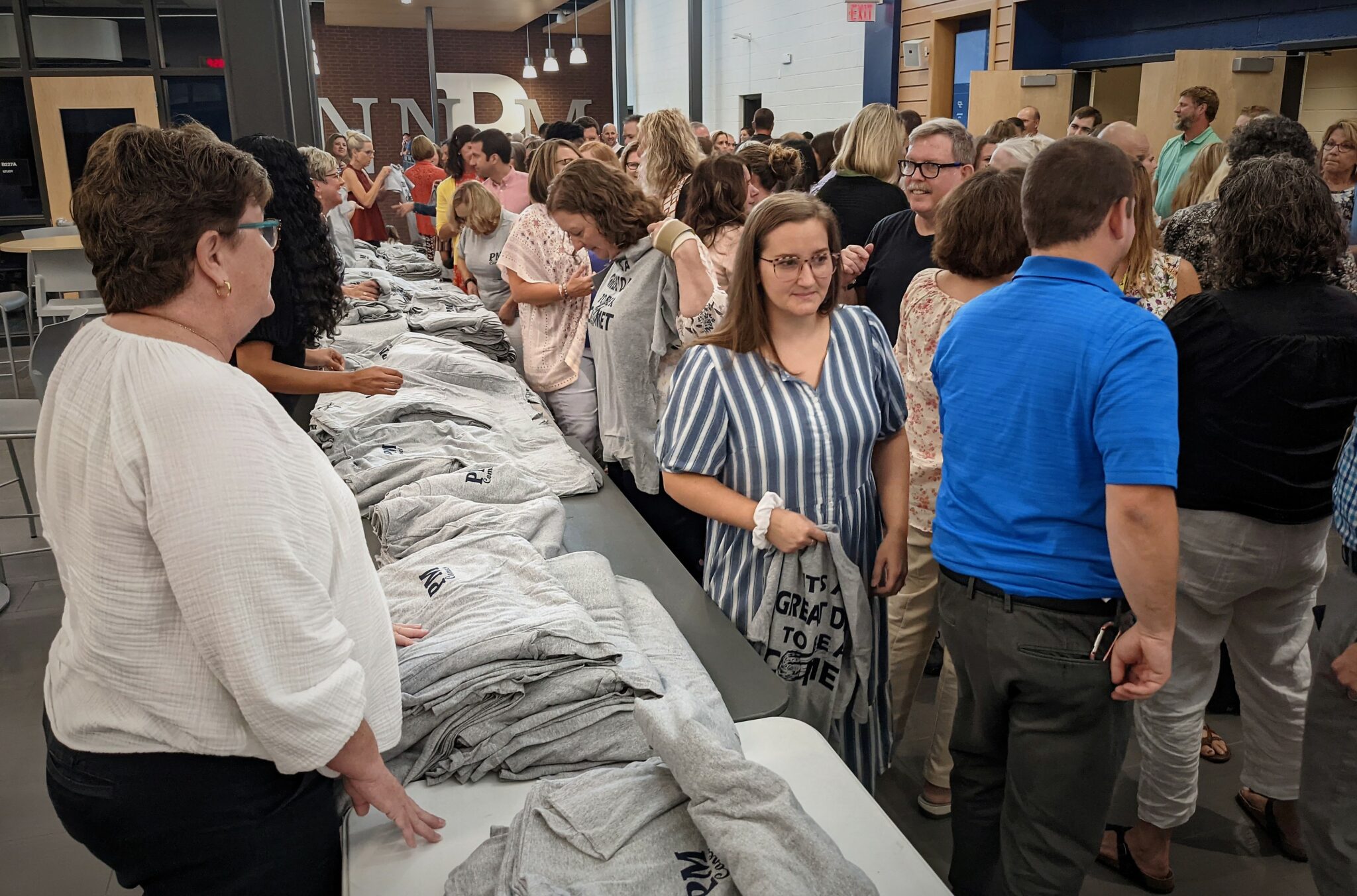 Photo of employees picking up T-shirts