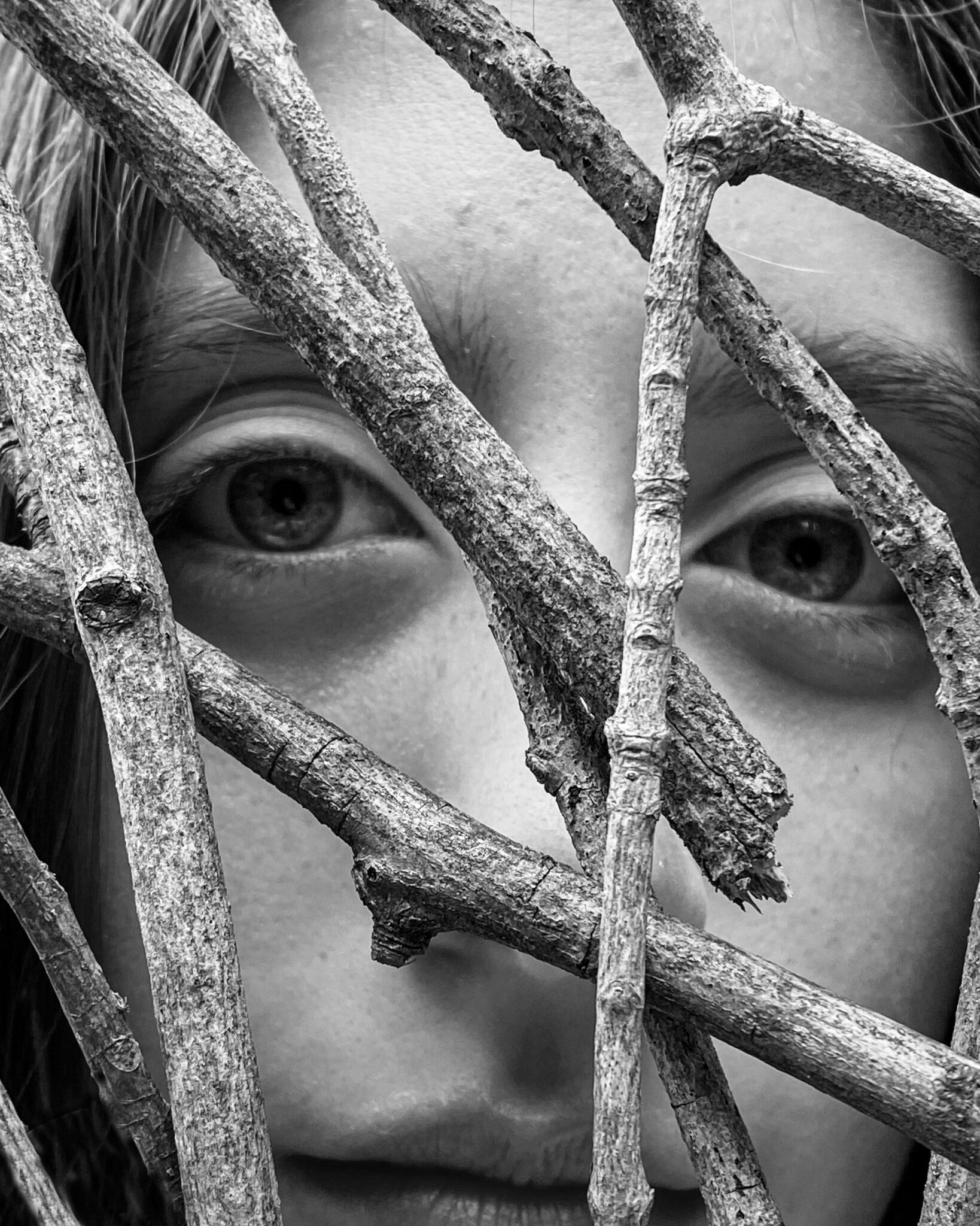 A photo of a face behind branches