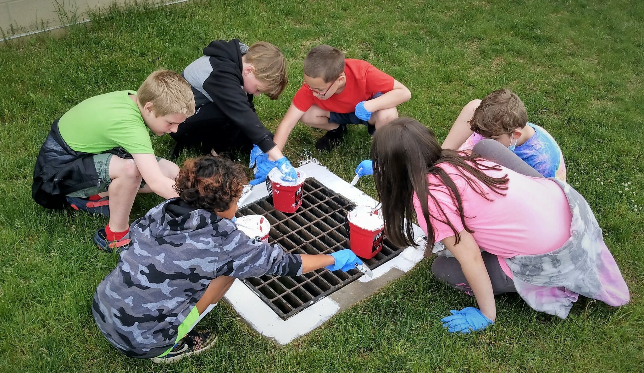 Photo of students painting a storm drain at Hambright Elementary.