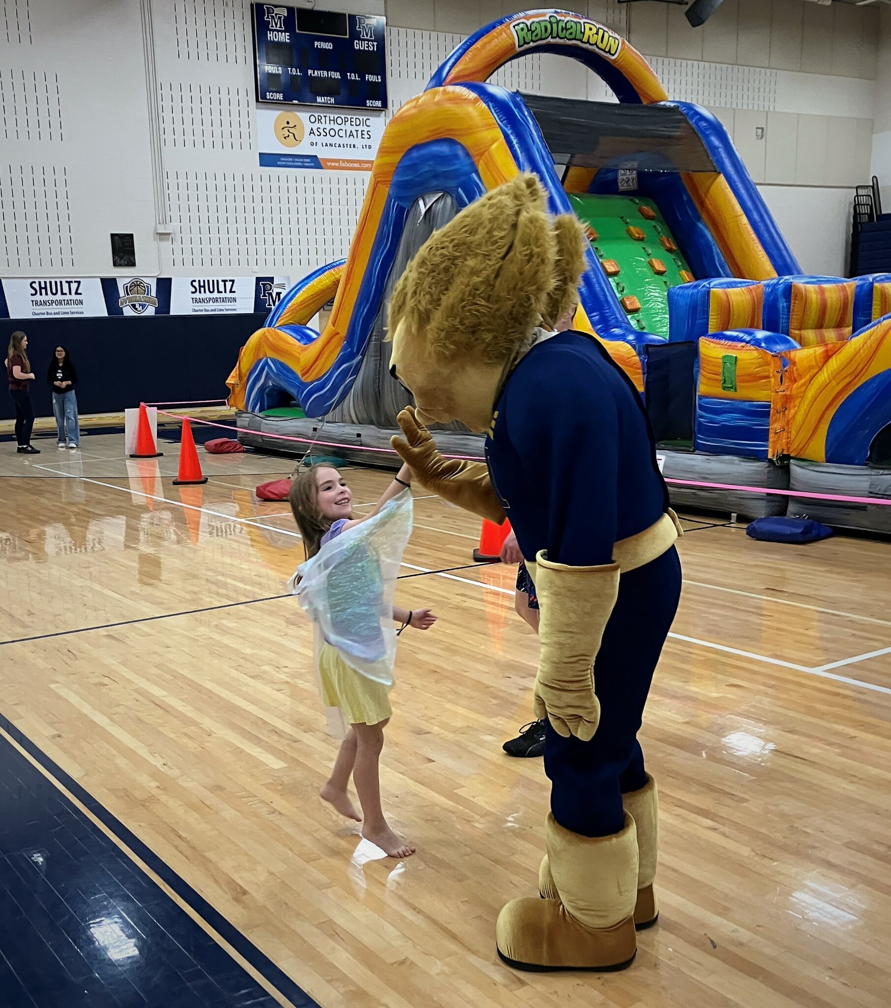 Photo of a young girl giving a high five to the Comet Man mascot.