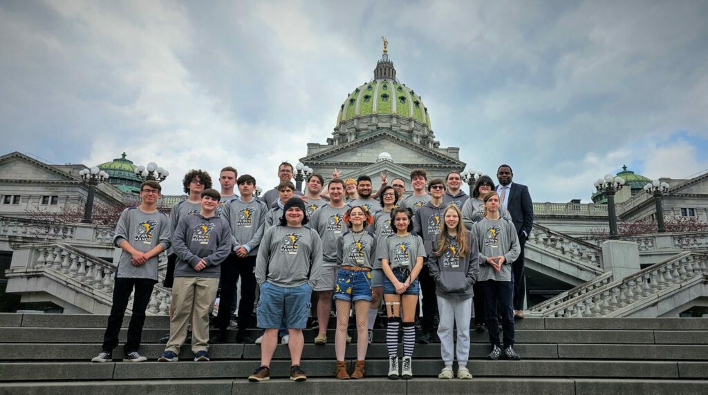 Photo of 22 esports team members with principal Baron Jones on the steps of the Capitol.