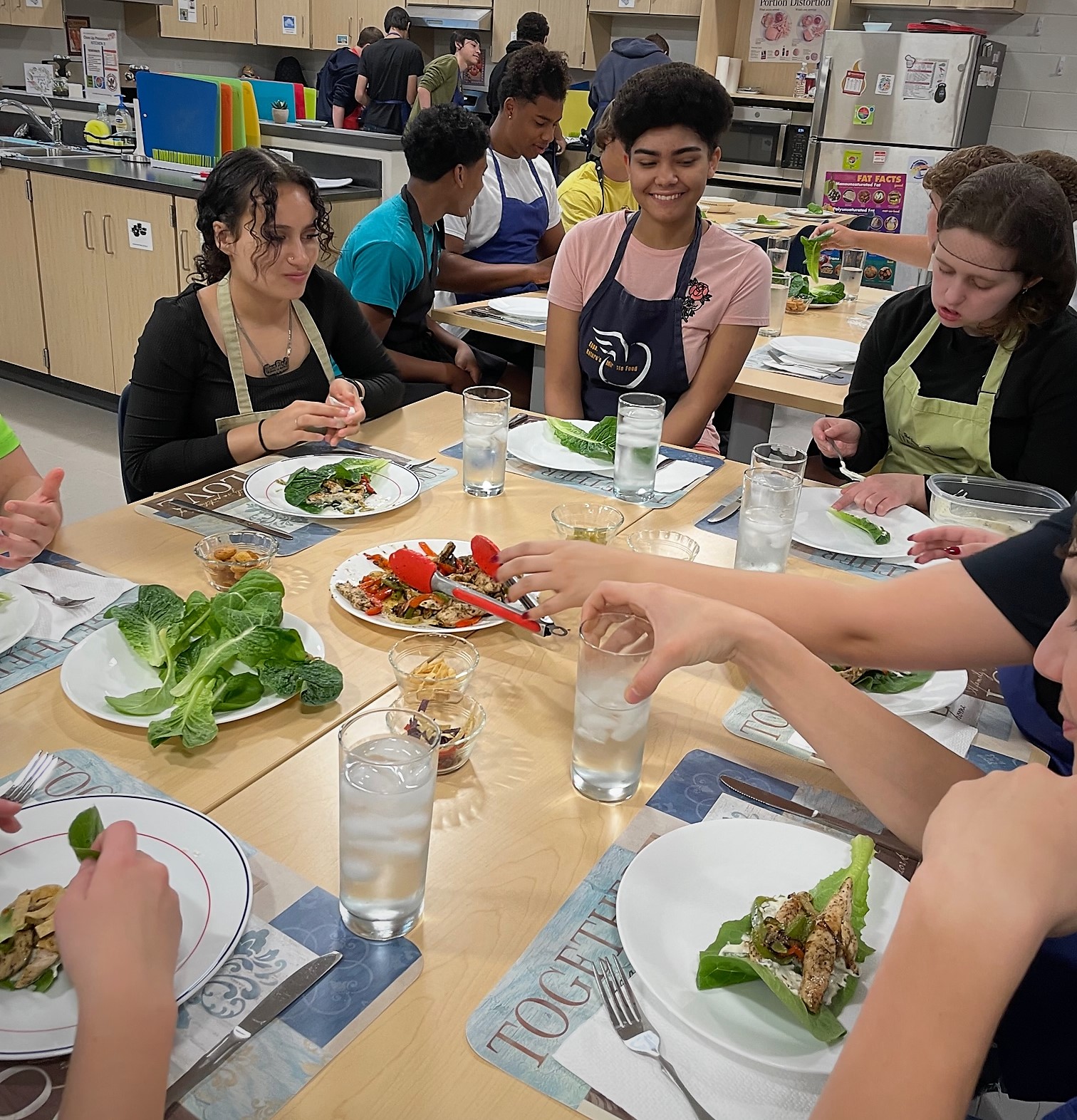 Seven students prepare to share a meal.